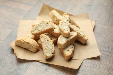 Geleneksel İtalyan badem bisküvileri (Cantucci) ve fındıklar ahşap masada, yakın plan.