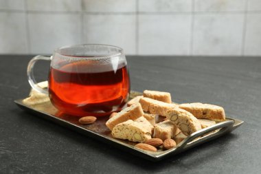 Geleneksel İtalyan badem bisküvileri (Cantucci), fındık ve fincan çay gri desenli masa, yakın plan