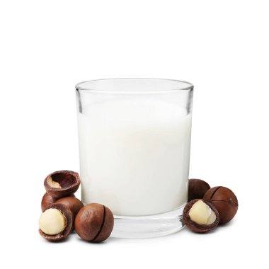 Beyaz üzerine izole edilmiş bir bardak Macadamia sütü ve fındık.