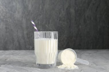 Lezzetli protein karışımı, cam ve toz ile kaplanmış gri desenli masa.