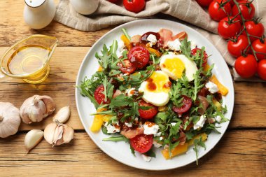 Tahta masada roka, yumurta, peynir ve sebzeli lezzetli salata.