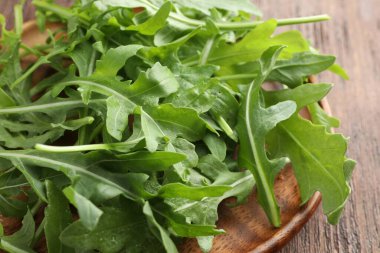 Taze yeşil roka yaprakları ahşap masada, yakın plan.