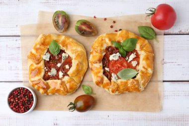 Beyaz ahşap masada domatesli, fesleğenli ve peynirli leziz galetler.