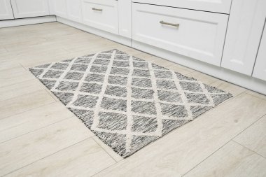 Mutfakta ahşap zeminde güzel bir halı.