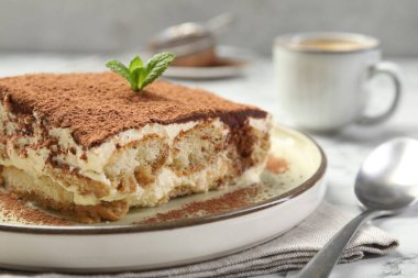 Beyaz masadaki lezzetli tiramisu parçası, yakın plan.