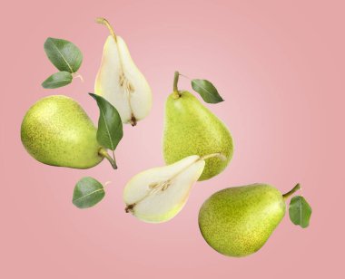 Fresh pears and green leaves in air on dasty pink background clipart