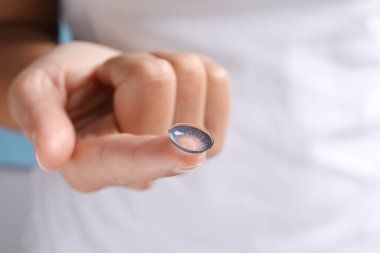 Açık mavi arkaplanda renk lensi tutan kadın, yakın plan