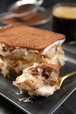 Siyah masada lezzetli tiramisu yiyorum, yakın plan.