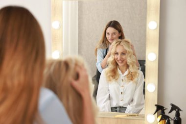 Saç kesimi. Salonda müşteriyle çalışan profesyonel kuaför, seçici odak