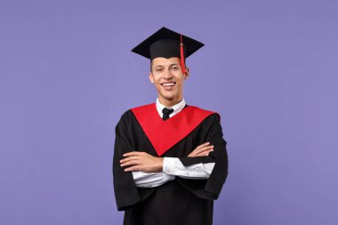 Mezuniyetten sonra kollarını çapraz yapmış mutlu bir öğrenci.