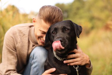 Gülümseyen adam ve sevimli köpek sonbahar günü açık havada