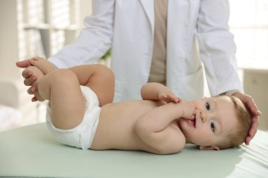 Klinikte küçük çocuğu olan bir çocuk doktoru, yakın plan. Bebeğin sağlığını kontrol ediyorum.