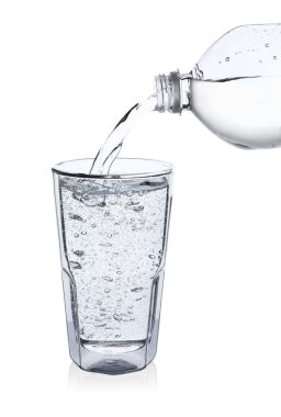 Beyaz arka planda şişeden cama soda dökülüyor.