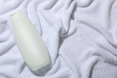 Yumuşak havluyla şampuan şişesinde, üst manzara. Metin için boşluk