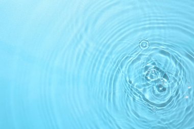 Açık mavi arkaplanda açık suyun dalgalı yüzeyi, üst görünüm