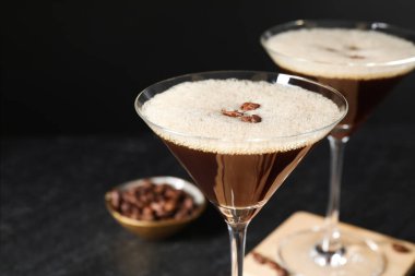 Siyah arka planda kahve çekirdekli enfes espresso martini, yakın plan.