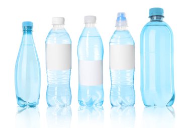 Beyaz zemin üzerinde su olan farklı plastik şişeler.
