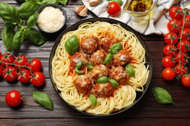 Köfteli lezzetli makarna ve ahşap masada malzemeler var.