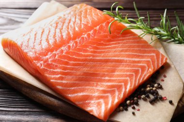 Taze somon ve baharatlar ahşap masada, yakın plan.