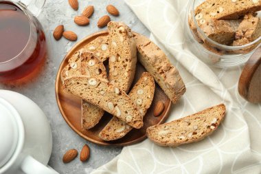 Geleneksel İtalyan badem bisküvileri (Cantucci), fındık ve çay gri desenli masa, düz uzanma