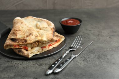 Etli, peynirli, domatesli ve soslu yarım dilim leziz calzone. Metin için boşluk