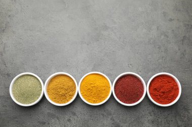 Gri masada farklı aromatik baharatlar, üst manzara. Metin için boşluk