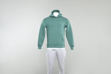 Şık bir kapüşonlu erkek mankeni ve açık arkaplanda eşofman altı.