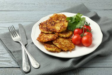 Gri ahşap masada servis edilen domatesli ve maydanozlu patatesli gözleme.