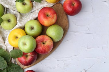 Farklı olgun elmalar beyaz masada, düz yerde. Metin için boşluk