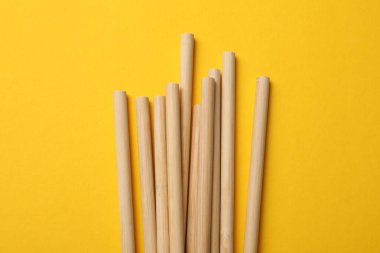 Sarı arka planda bambu pipetleri, üst görünümde