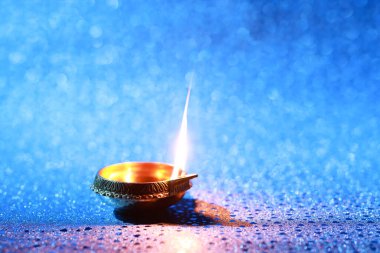 Diwali kutlaması. Mavi arka planda Diya lambası. Metin için boşluk