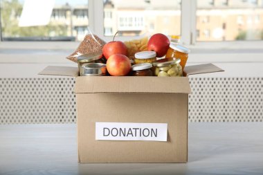 İçerideki ahşap masada bağış yapmak için farklı gıda ürünleri.