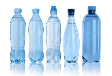 Beyaz zemin üzerinde su olan farklı plastik şişeler.