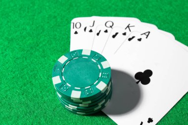 Yeşil masada kağıt ve poker fişleri, yakın plan.