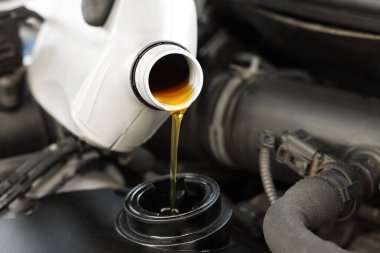 Otomobil motoruna motor yağı döken adam, yakın plan.