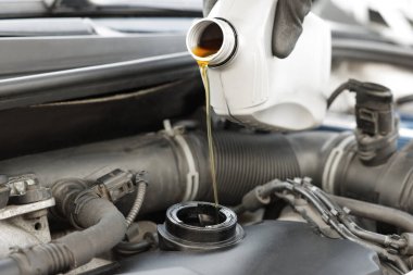 Otomobil motoruna motor yağı döken adam, yakın plan.
