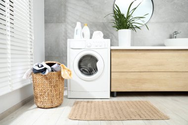 Banyoda yerde çamaşır dolu bir sepet.