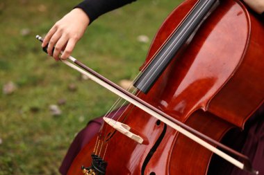 Dışarıda çello çalan kadın, yakın plan. Klasik müzik aleti.