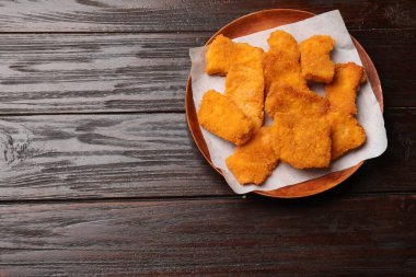 Tasty chicken nuggets on wooden table, top view. Space for text