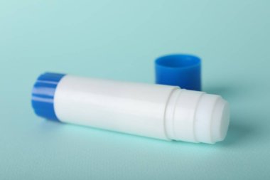 Açık mavi arkaplanda yapıştırıcı ve kapak, yakın plan