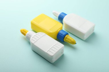 Açık mavi arkaplanda yapışkan şişeler