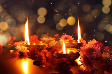 Diwali kutlaması. Diya lambaları ve arka planda güzel çiçekler. Bokeh etkisi