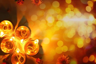 Diwali kutlaması. Diya lambaları ve arka planda Bokeh efektli güzel çiçekler, üst görünüm