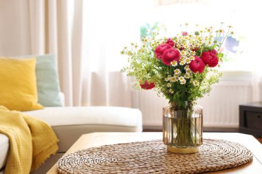 Güzel ranunculus çiçekleri ve vazolar içerideki masada.