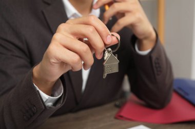 Masada anahtarı olan bir emlakçı, yakın plan.
