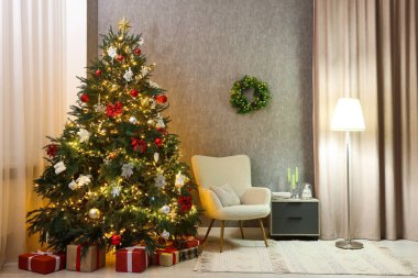 Güzel bir Noel ağacı, koltuk ve lambası olan rahat bir oda. Tatil için iç tasarım
