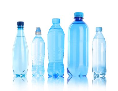 Beyaz zemin üzerinde su olan farklı plastik şişeler.