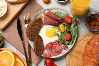 Gri mermer masada kahvaltıda servis edilen farklı lezzetli yiyecekler.