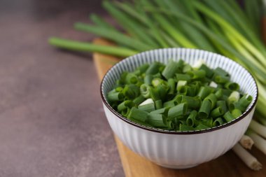 Kavanozda doğranmış yeşil soğan ve kahverengi masa sapları, yakın plan. Metin için boşluk