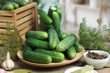 Taze salatalıklar, ahşap masada dereotu ve baharatlar, yakın plan. Turşu hazırlama